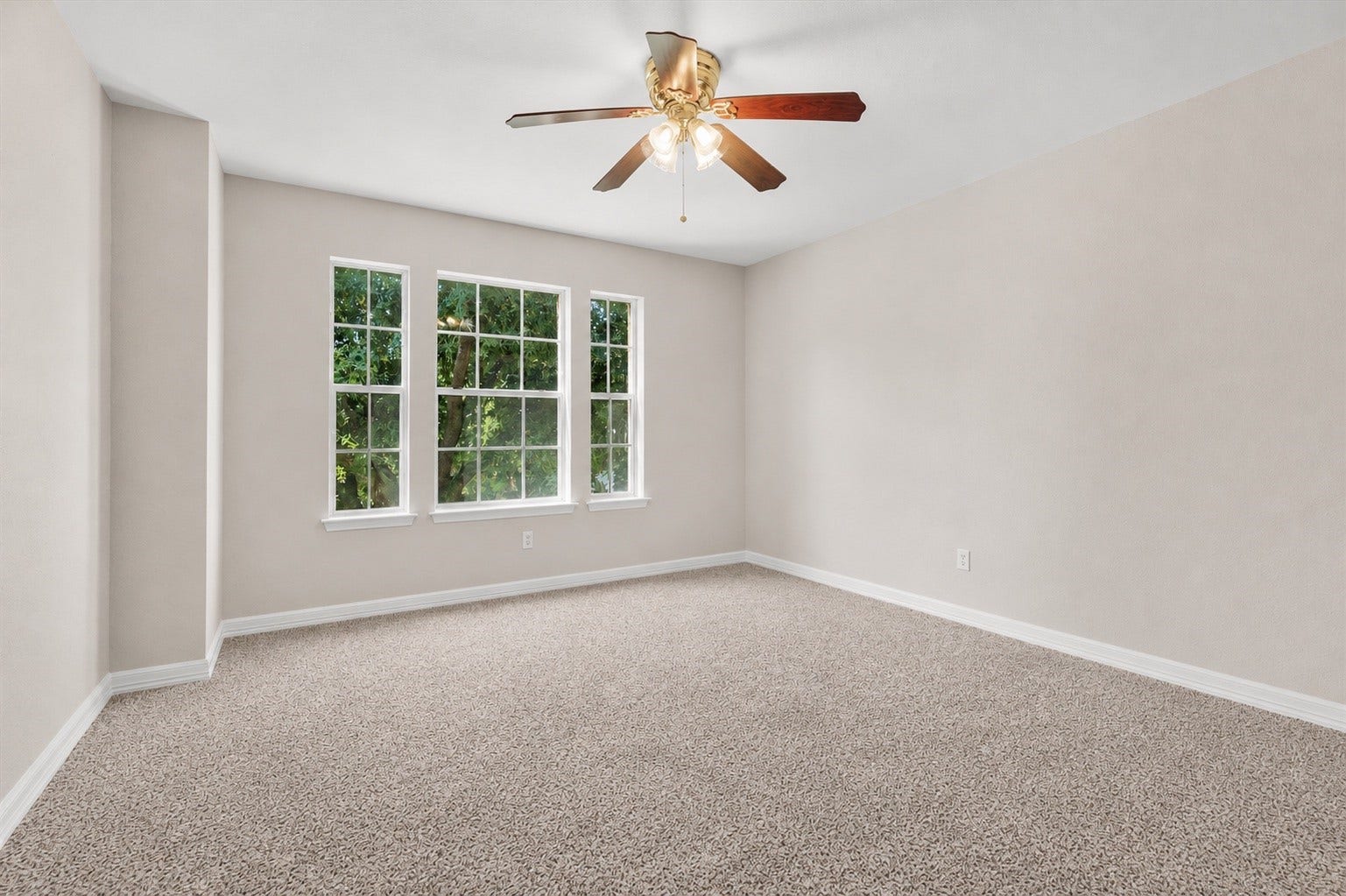 5918 Stirring Winds Lane, Houston, TX 77086 Secondary bedroom filled with natural light from multiple windows and overlooking mature trees.