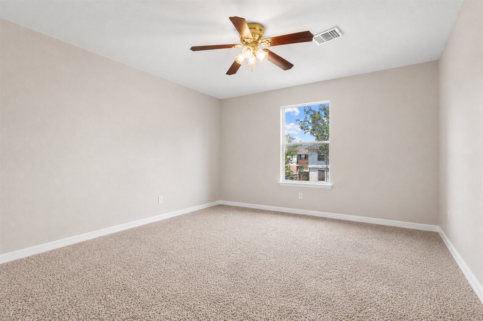 5918 Stirring Winds Lane, Houston, TX 77086 Spacious secondary bedroom with plush carpeting, ceiling fan, and plenty of room for a full bedroom setup.