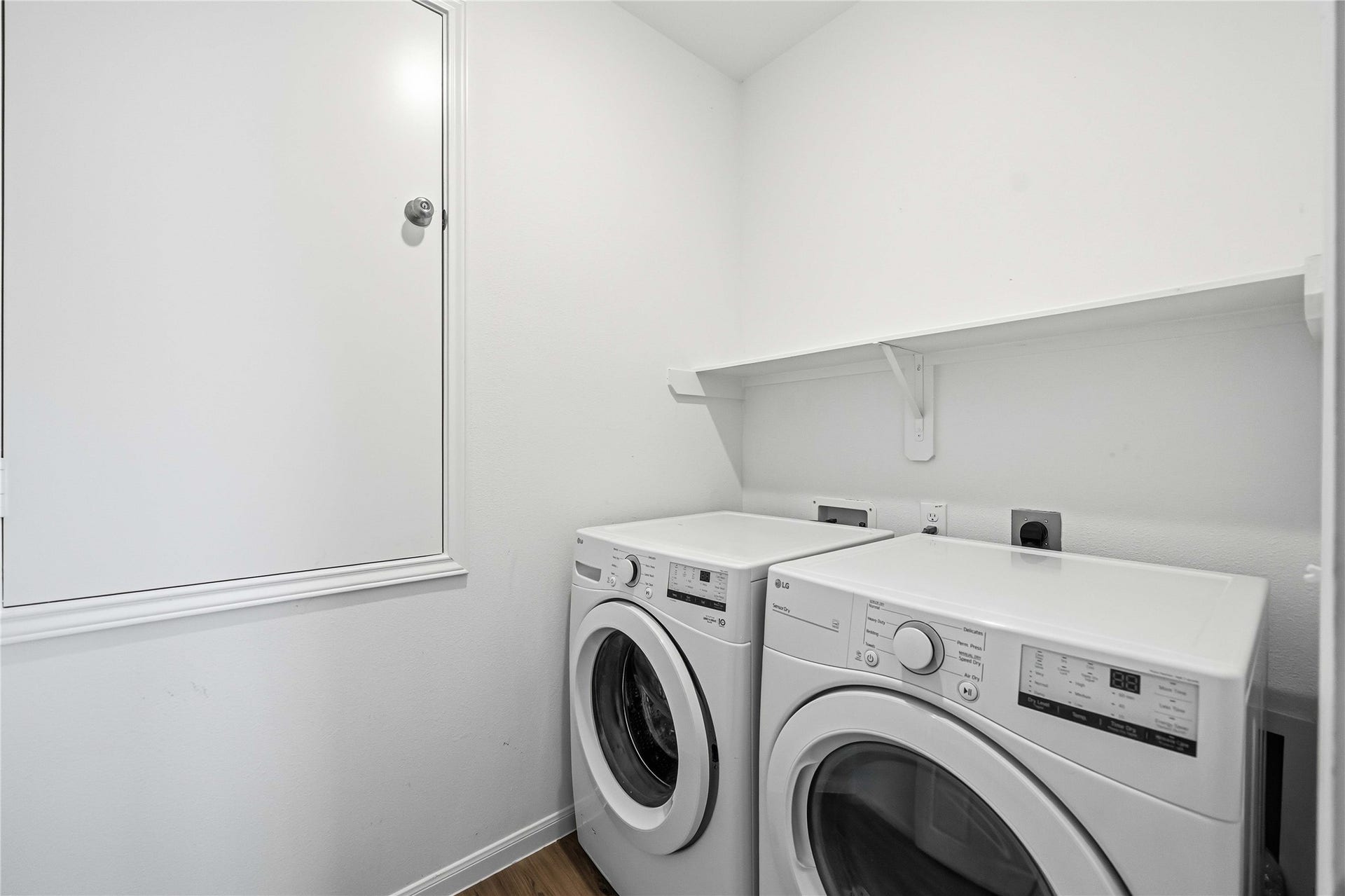 Laundry room with overhead shelving and space for side-by-side appliances.