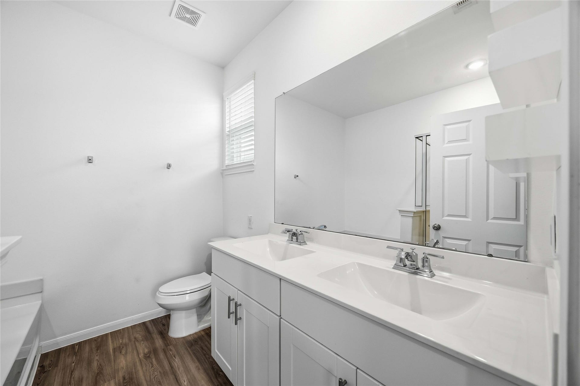 Primary bathroom with a dual-sink vanity and oversized mirror.