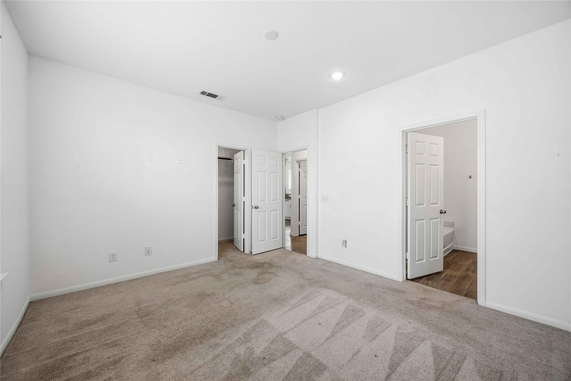 Primary suite with access to the bathroom and walk-in closet.