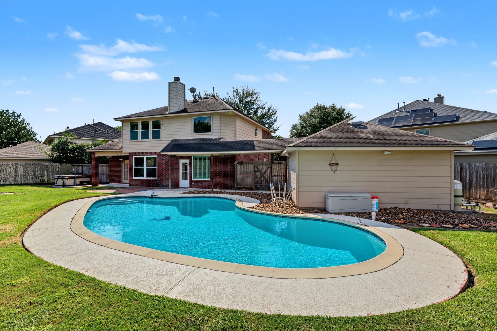 Backyard  sparkling pool, perfect for relaxation and entertainment, surrounded by a well-maintained lawn and privacy fencing.