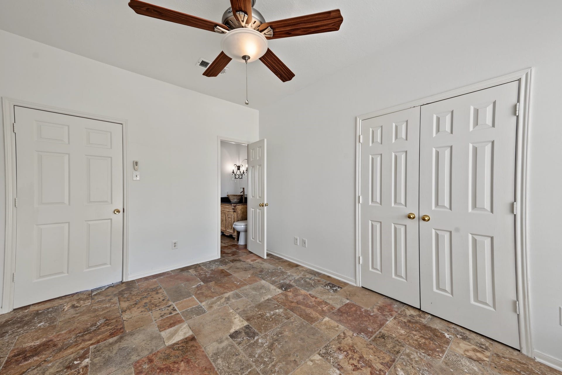 This spacious room also has tiled flooring, a ceiling fan, and ample closet space, leading into a stylish updated three piece bathroom with a walk in shower.