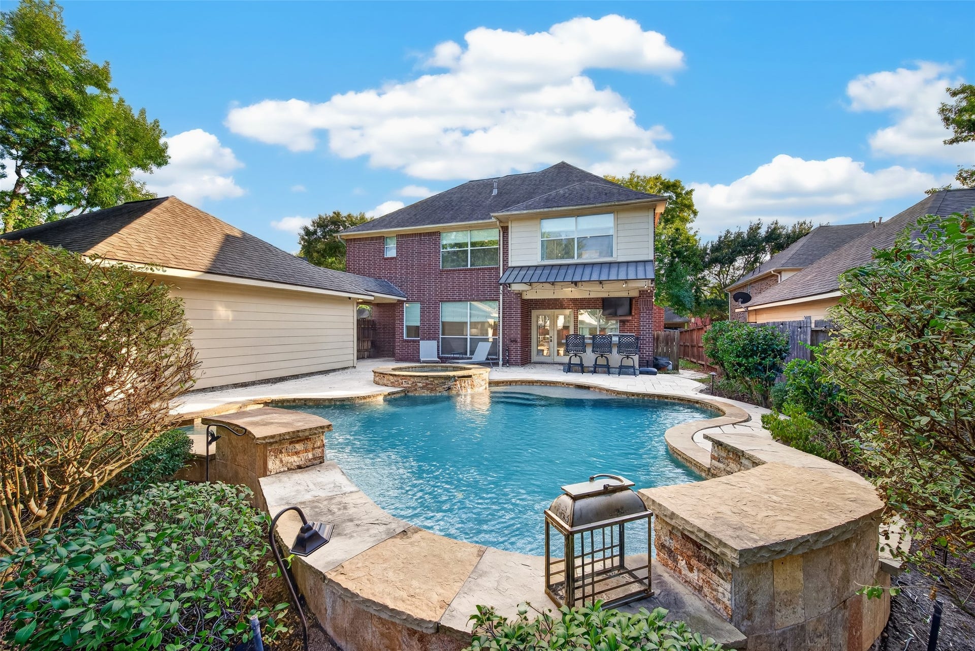 7707 Stone Arbor Drive, Sugar Land, TX 77479 A BACKYARD WORTH COMING HOME TO! Looking back toward the home, you can appreciate how beautifully the pool, spa, outdoor kitchen & generous patio areas come together. French doors connect the indoor living spaces to this inviting outdoor retreat. From morning coffee beside the pool to evenings spent entertaining under the stars, there's so much to enjoy here.