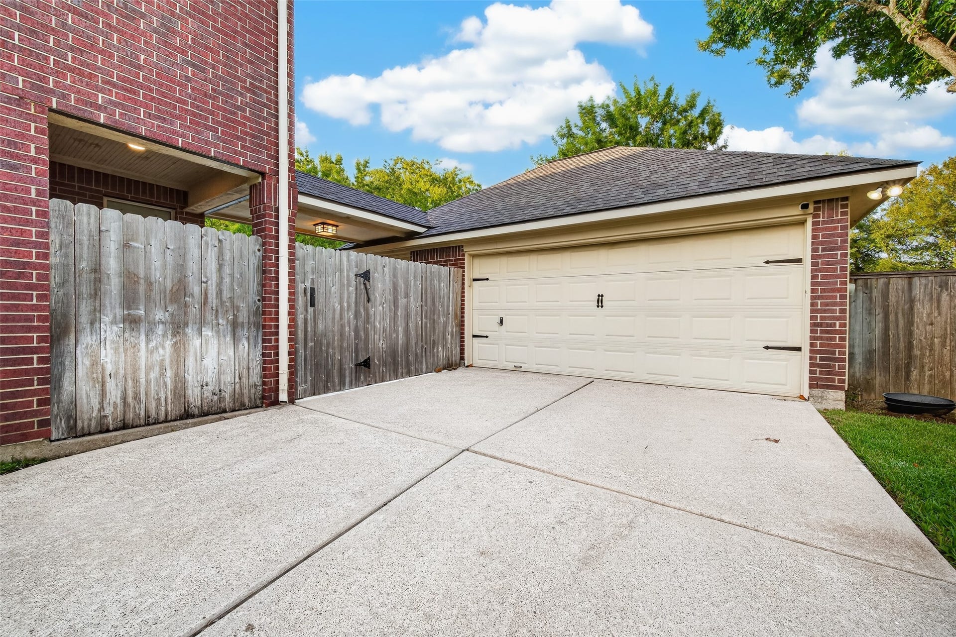 7707 Stone Arbor Drive, Sugar Land, TX 77479 AN OVERSIZED DETACHED GARAGE! The detached 2-car garage offers plenty of room for parking, while the wide concrete driveway provides additional space. A covered breezeway connects the house & garage, keeping you sheltered from the rain as you come & goa welcome convenience during those Houston downpours! Gated access also provides a convenient connection to the backyard.