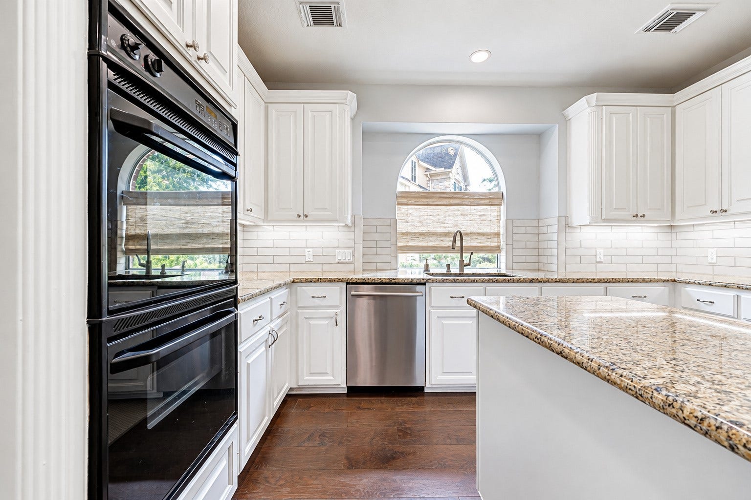 7707 Stone Arbor Drive, Sugar Land, TX 77479 PLENTY OF ROOM TO GET CREATIVE IN THE KITCHEN! Whether preparing a quick weeknight dinner or a special holiday meal, the double ovens make it easier to manage multiple dishes at once. Generous cabinetry provides storage for cookware, dishes & everyday essentials, while the granite countertops offer plenty of room for meal preparation. The arched window above the sink brings natural light into the heart of the kitchen.