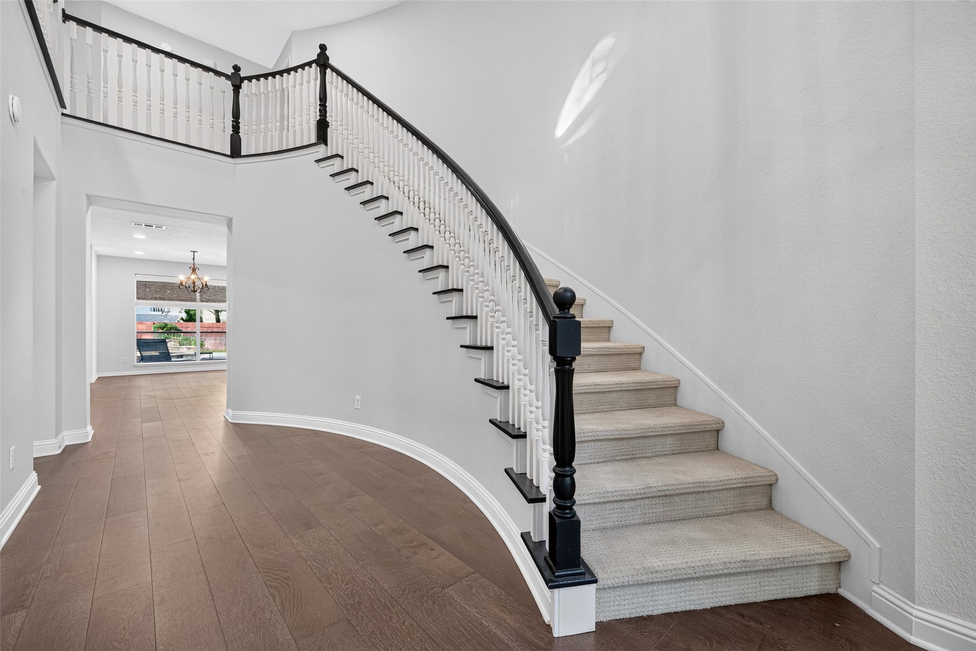 7707 Stone Arbor Drive, Sugar Land, TX 77479 AN ELEGANT FIRST IMPRESSION! The gracefully curved staircase is a beautiful architectural centerpiece, with its contrasting dark handrail, white balusters and sweeping design. Wood flooring continues through the foyer and adjoining living spaces, creating a warm, cohesive look. It's easy to imagine this space decorated for the holidays, with garland winding along the staircase and a soaring Christmas tree illuminating the foyer.