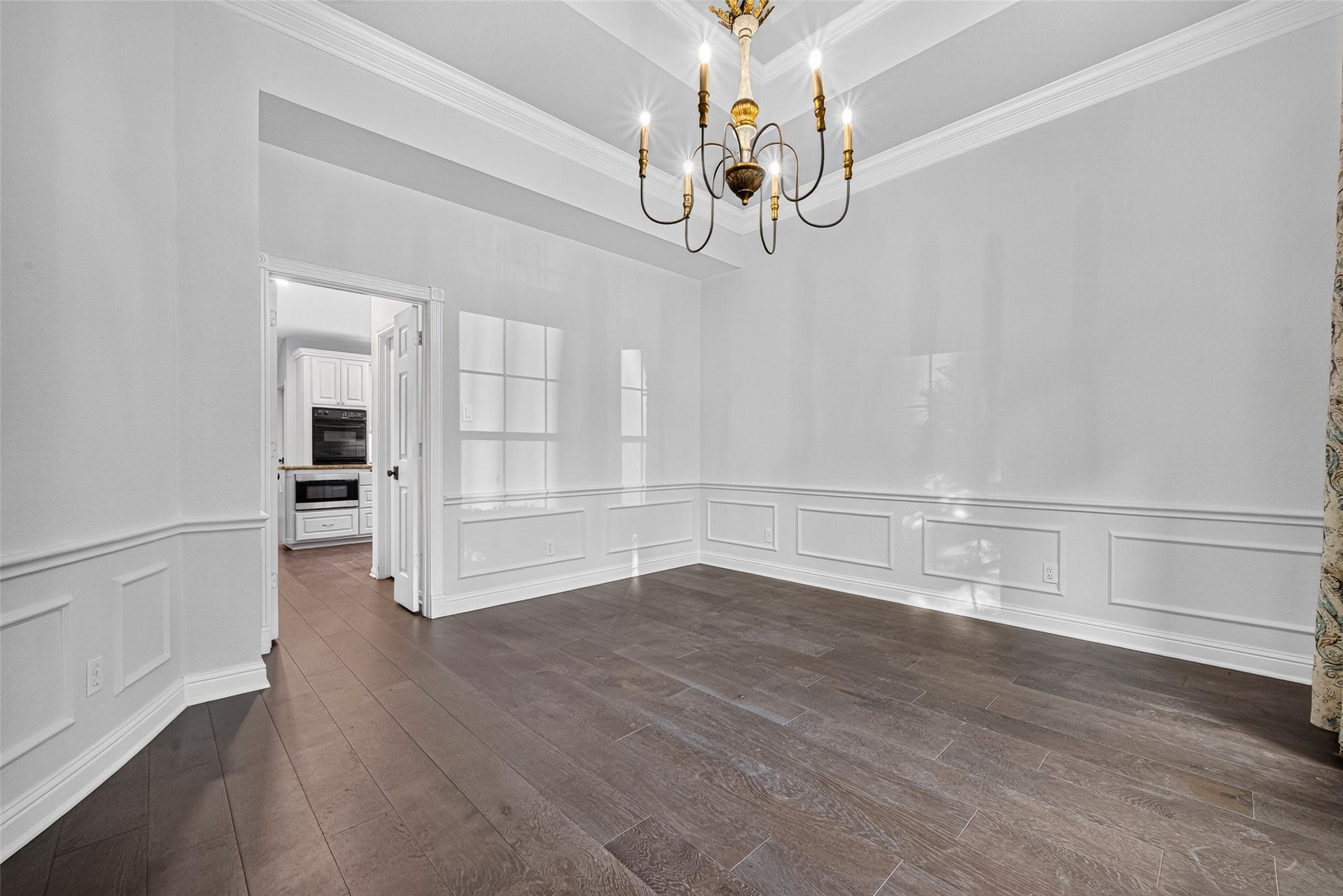 7707 Stone Arbor Drive, Sugar Land, TX 77479 BEAUTIFUL DETAILS FROM EVERY ANGLE! This view offers another look at the Formal Dining Room's tray ceiling, elegant chandelier, decorative molding and beautiful wood flooring. Notice the doorway leading directly into the Kitchena convenient connection when bringing dinner to the table, serving guests or returning for seconds during a holiday feast. Thoughtfully positioned, these two rooms naturally complement one another.