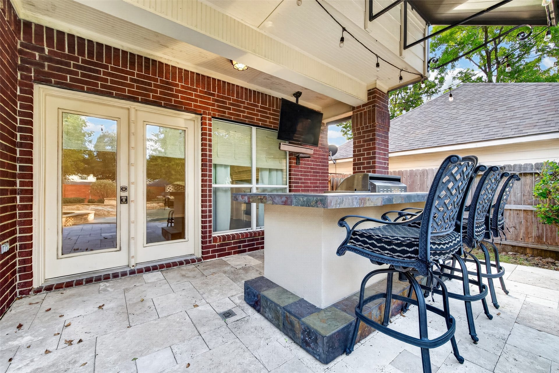 7707 Stone Arbor Drive, Sugar Land, TX 77479 PULL UP A CHAIR & STAY AWHILE! The covered outdoor bar offers a wonderful gathering spot with countertop seating, a mounted TV & easy access to the Family Room through French doors. Imagine catching the game while dinner sizzles on the grill, sharing appetizers with friends or simply relaxing after an afternoon in the pool. With string lights overhead & the outdoor kitchen just steps away, entertaining here is easy!