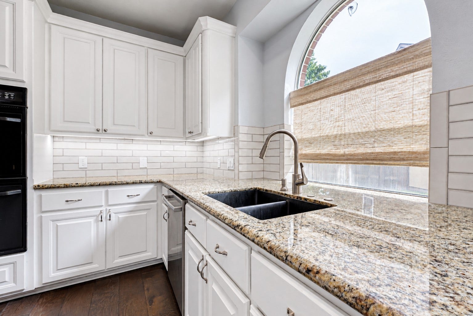 7707 Stone Arbor Drive, Sugar Land, TX 77479 IT'S ALL IN THE DETAILS! The granite countertops provide generous workspace surrounding the undermount double-basin sink, while the gooseneck faucet makes everyday cleanup convenient. White cabinetry, subway tile backsplash & undercabinet lighting brighten the space. And that beautiful arched window? It's a lovely architectural feature that makes even washing dishes a little more enjoyable.