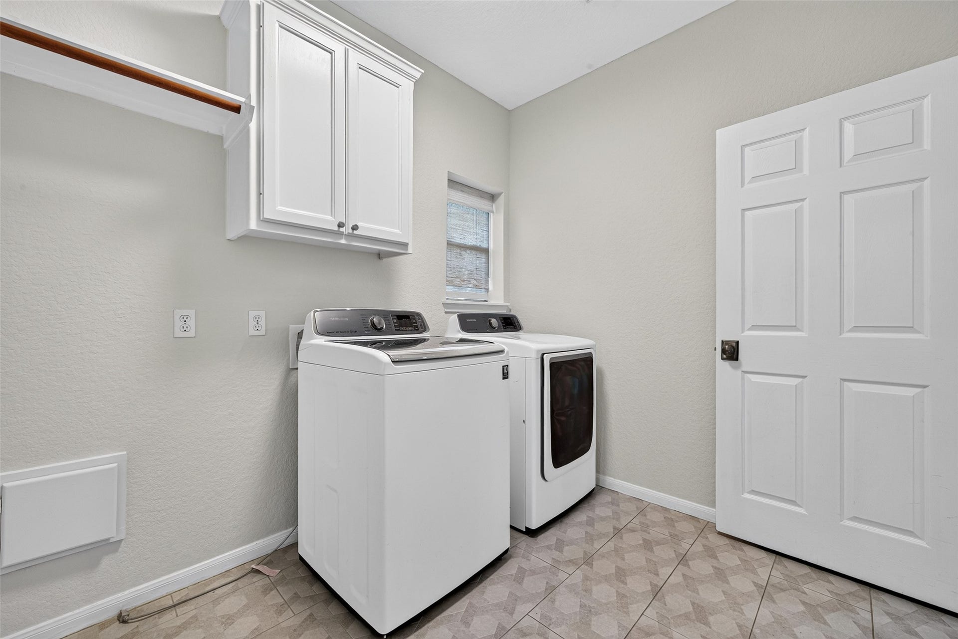 7707 Stone Arbor Drive, Sugar Land, TX 77479 A UTILITY ROOM WITH EXTRA CONVENIENCES! This dedicated Utility Room comes complete with a full-size washer & dryer, built-in cabinetry for storing laundry supplies & a clothes rod for hanging freshly laundered garments. A window welcomes natural light, while tile flooring makes cleanup easy. There's even additional space for an upright refrigerator or freezerperfect for storing extra groceries, frozen foods or refreshments for those backyard pool parties! Practical and thoughtful design.