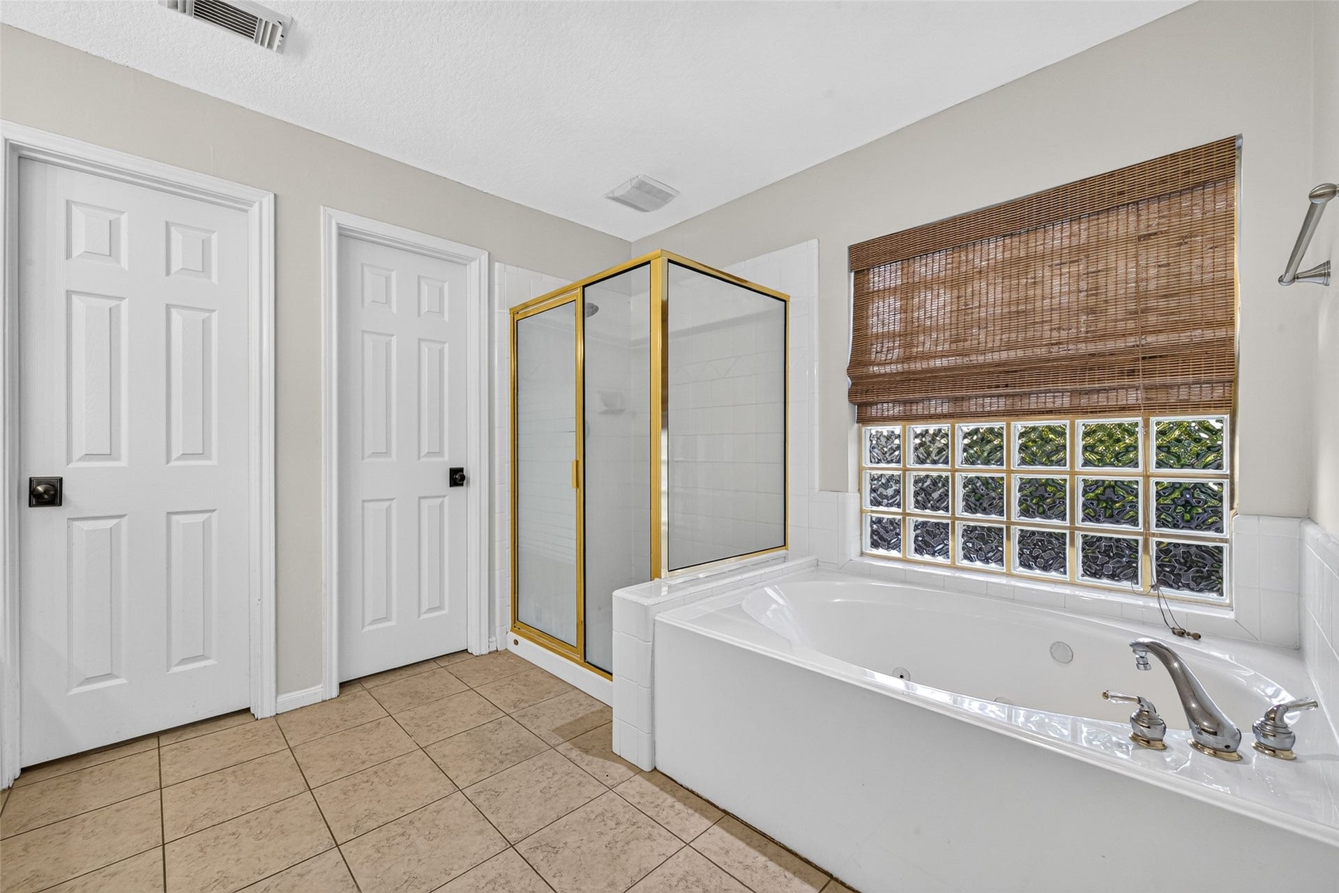 7707 Stone Arbor Drive, Sugar Land, TX 77479 A LITTLE TIME TO RELAX & RECHARGE! After a busy day, imagine soaking in the jetted tub with a favorite book or enjoying a refreshing shower in the separate glass-enclosed shower. A glass-block window welcomes natural light while providing privacy, and a woven shade adds warmth to the space. With both bathing options available, this Primary Bath offers flexibility for a quick morning routine or a leisurely evening unwind.