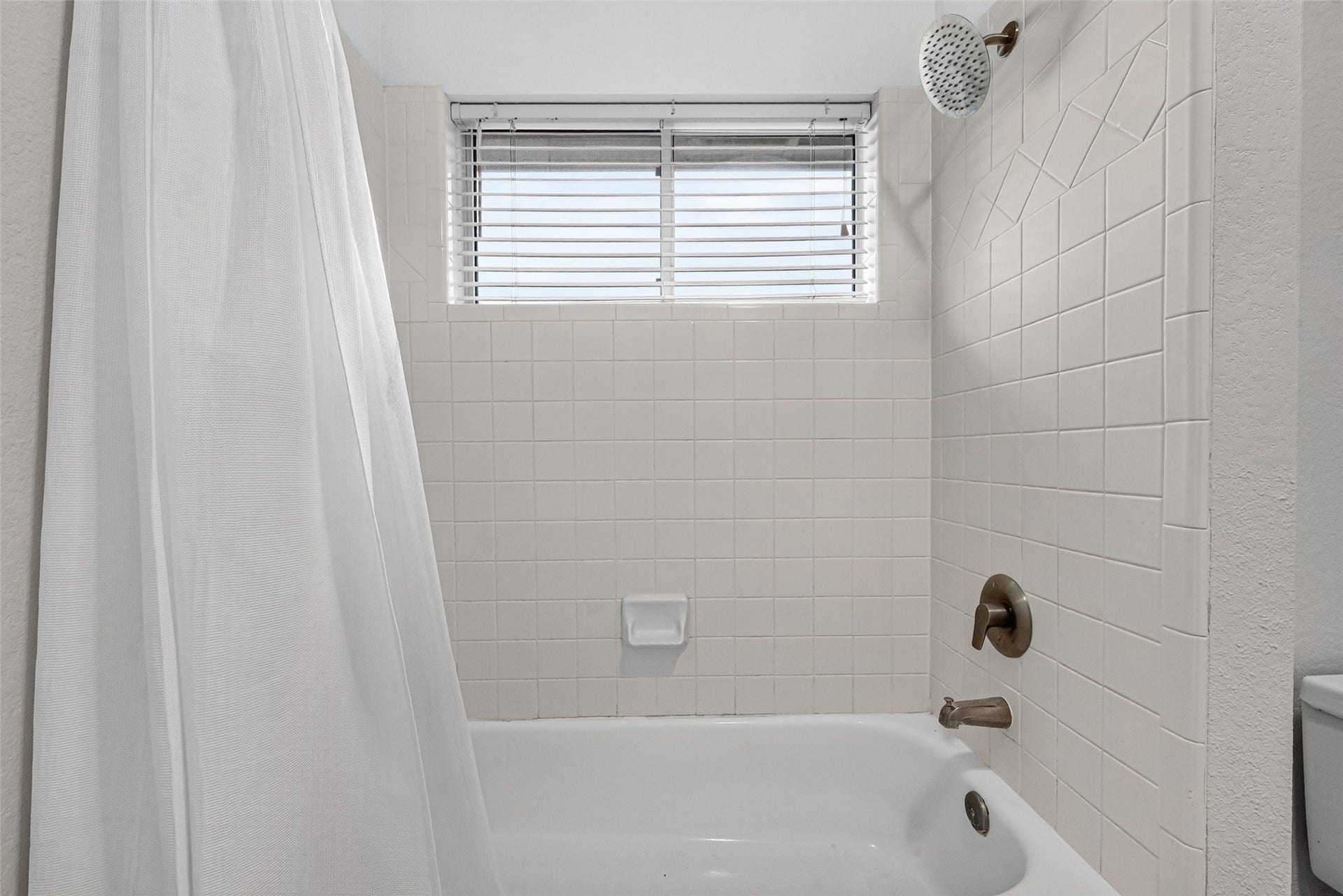 7707 Stone Arbor Drive, Sugar Land, TX 77479 CONVENIENCE BETWEEN TWO BEDROOMS! The shared bathing area features a tub/shower combination with white tile surround, a decorative tile accent & a window welcoming natural light. A separate water closet provides additional privacy, while the connecting vanity areas make this Jack & Jill arrangement especially practical.