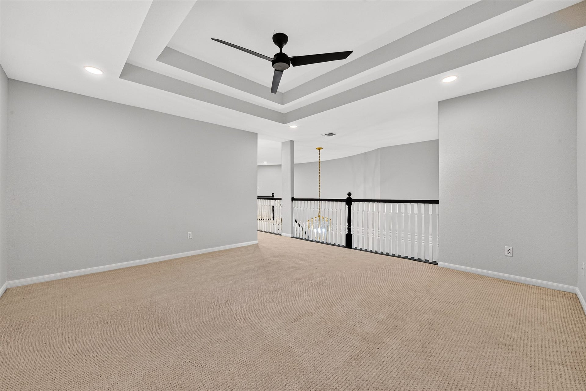 7707 Stone Arbor Drive, Sugar Land, TX 77479 A LITTLE SEPARATION GOES A LONG WAY! This view offers another perspective of the spacious upstairs Game Room, highlighting its attractive tray ceiling & open connection to the staircase landing. Thoughtfully situated apart from all the upstairs bedrooms, this versatile living area provides a separate place for watching television, playing games, pursuing hobbies or entertaining friends without disturbing those enjoying a little peace & quiet in their bedrooms.