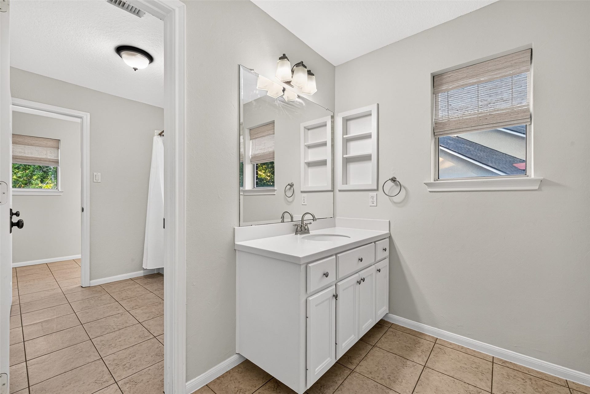 7707 Stone Arbor Drive, Sugar Land, TX 77479 CONVENIENT ACCESS FROM THE UPSTAIRS HALLWAY! This second vanity area of Bath #2 is accessible from the hallway, making it convenient for guests enjoying the upstairs Gameroom as well as Bedroom #3. Featuring a separate sink, countertop, cabinetry, built-in shelving & a window with woven blinds, this thoughtful arrangement provides additional privacy & flexibility.