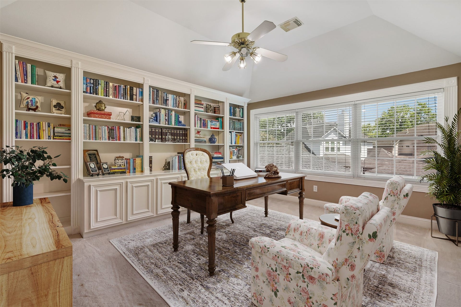 1414 Forest Bend Drive, Sugar Land, TX 77479 Upstairs game room features wall of built in bookshelves and cabinet space. There is a wall of windows for plenty of natural light as well as elevated ceiling with fan.
