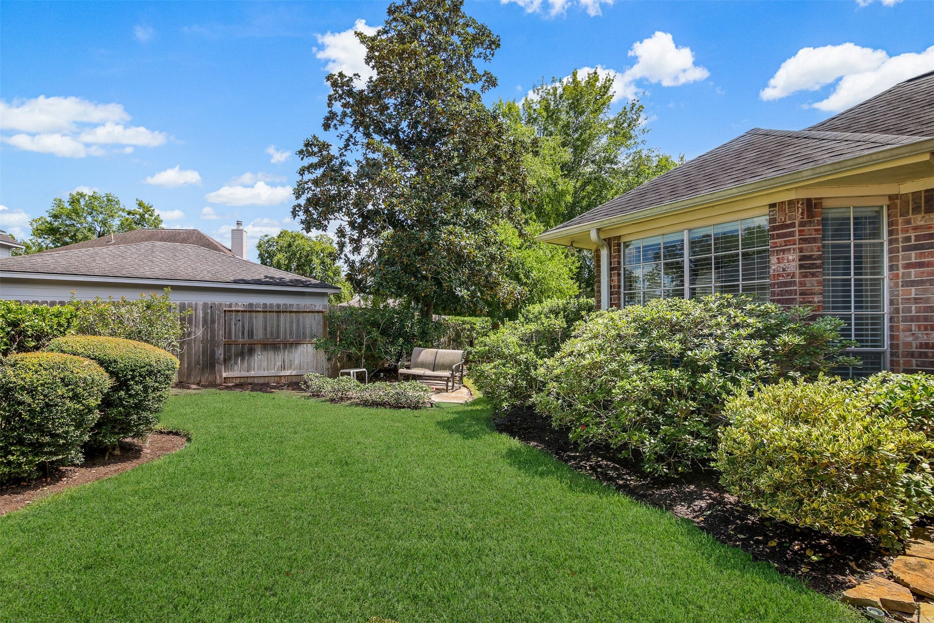 1414 Forest Bend, Sugar Land, TX 77479 View of the well maintained and professionally landscaped backyard with sitting area. *Grass has been virtually enhanced*