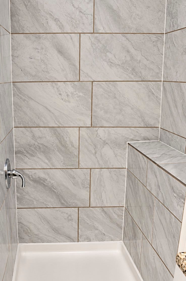 Quarters' shower with sleek, large-format marble tile.
