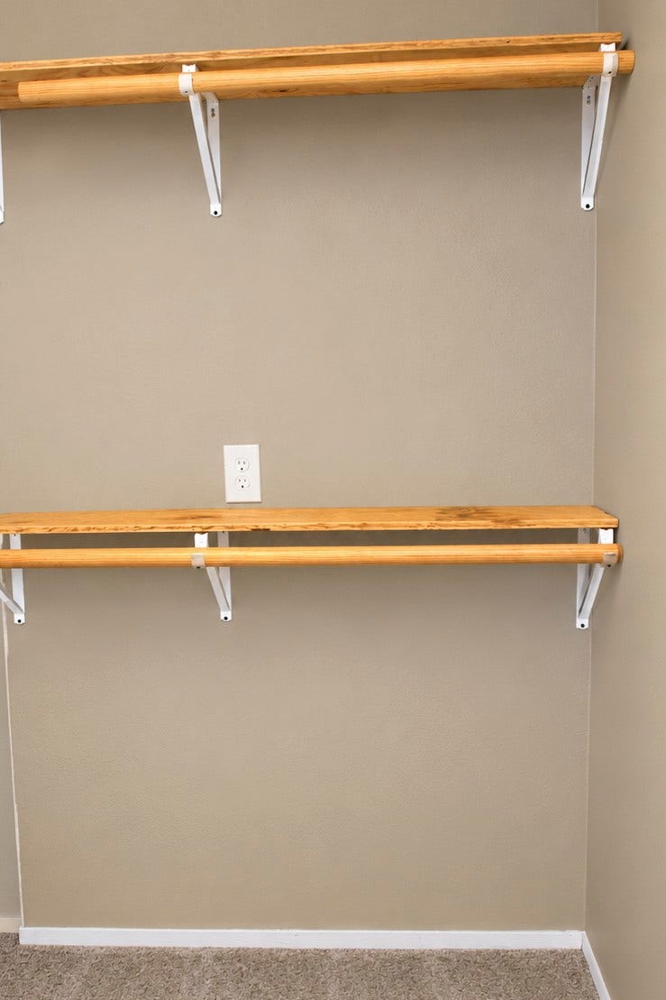 Cozy closet space featuring rustic dual wooden shelves.