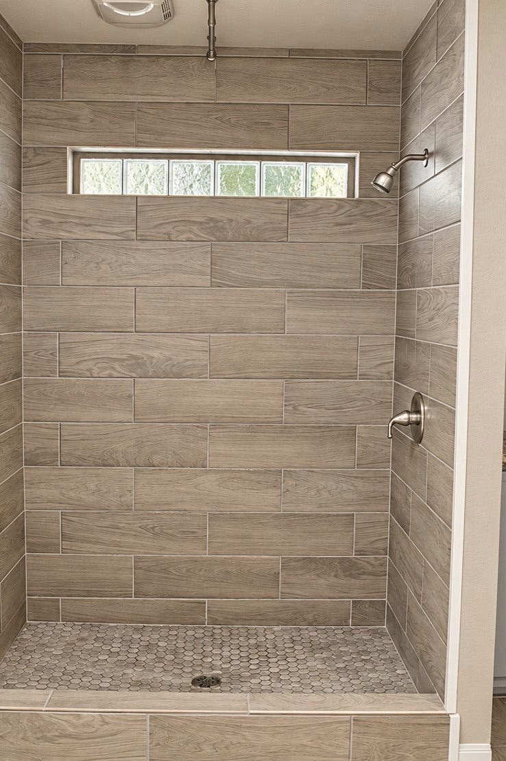 Elegant walk-in shower in Primary Bath featuring modern gray tile.