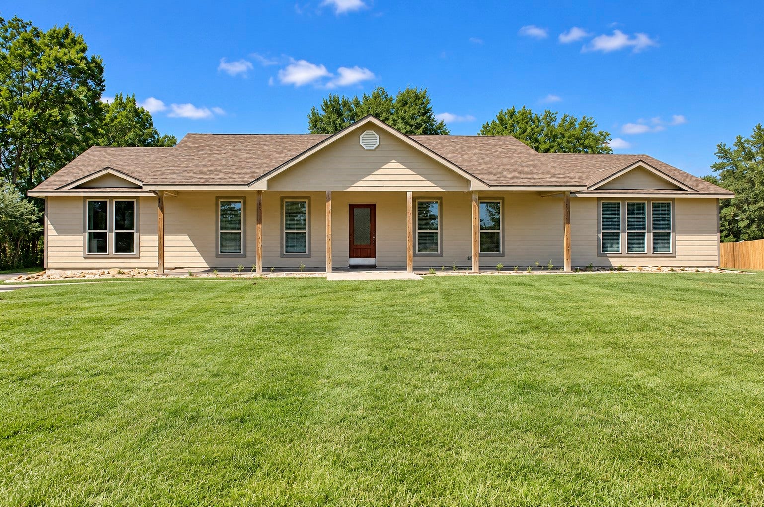 Charming ranch-style home with a welcoming front porch, nestled on a spacious acreage.
