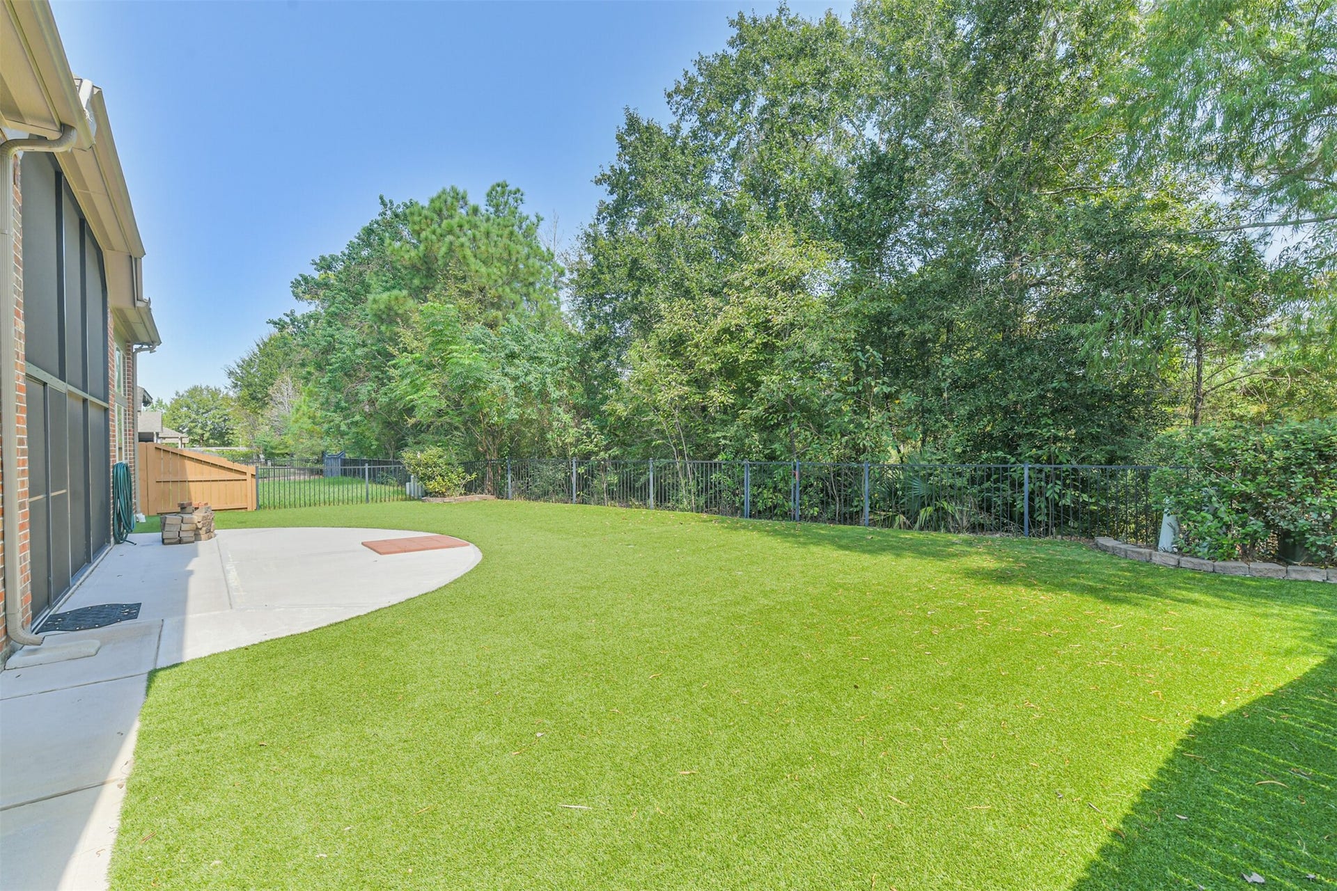 1735 Wickham Reach Drive, Spring, TX 77386 Another backyard view highlighting the open lawn and wooded surroundings.