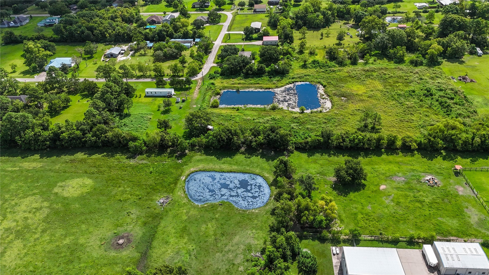 Expansive land featuring a serene pond, ideal for recreational activities, surrounded by lush greenery and offering a peaceful rural setting.