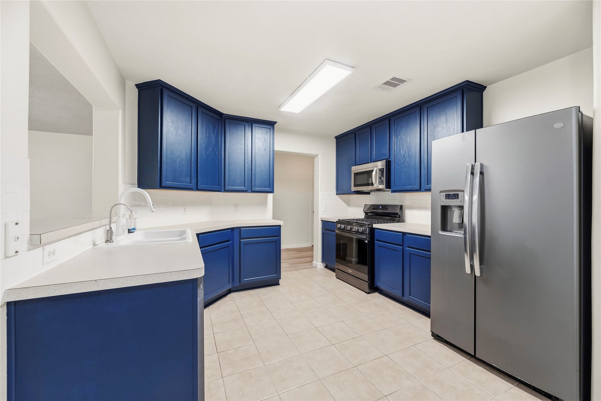 14223 Pinefrost Lane, Cypress, TX 77429 Well-appointed kitchen featrures painted cabinets, tile backsplash, stainless steel appliances, gas range and a breakfast bar.