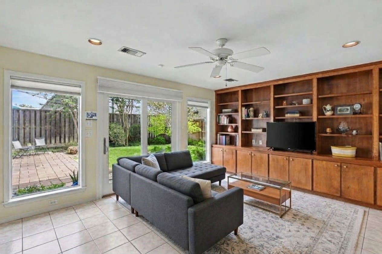 4102 Portsmouth Avenue, Houston, TX 77027 Large and relaxing family room set with built-ins and an incredible view to the backyard. Window treatments in place. (virtually staged)
