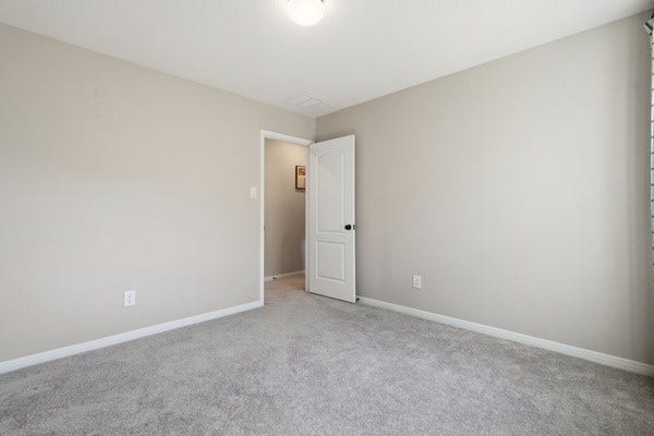 15334 Silver Breeze Lane, Houston, TX 77044 Spacious bedroom with plush carpeting and soft neutral walls, offering a cozy and inviting atmosphere.