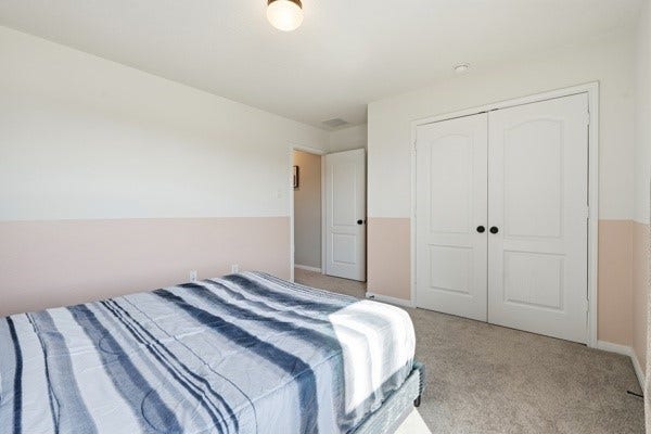 15334 Silver Breeze Lane, Houston, TX 77044 Bright and cozy bedroom with soft carpet, featuring a spacious closet with double doors and ample natural light.