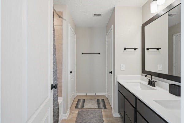 15334 Silver Breeze Lane, Houston, TX 77044 Sleek bathroom featuring a double vanity with modern fixtures, ample storage, and a walk-in shower.