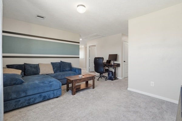 15334 Silver Breeze Lane, Houston, TX 77044 Spacious living area with a cozy sectional sofa, modern accent wall, and a convenient desk nook for work or study.