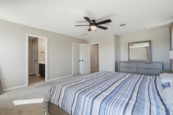 15334 Silver Breeze Lane, Houston, TX 77044 Spacious bedroom featuring a modern ceiling fan, neutral tones, and an ensuite bathroom for added convenience.