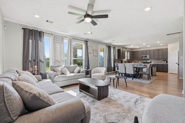 15334 Silver Breeze Lane, Houston, TX 77044 Spacious open-concept living area with abundant natural light, featuring a cozy seating space, elegant dining area, and modern kitchen with stainless steel appliances.
