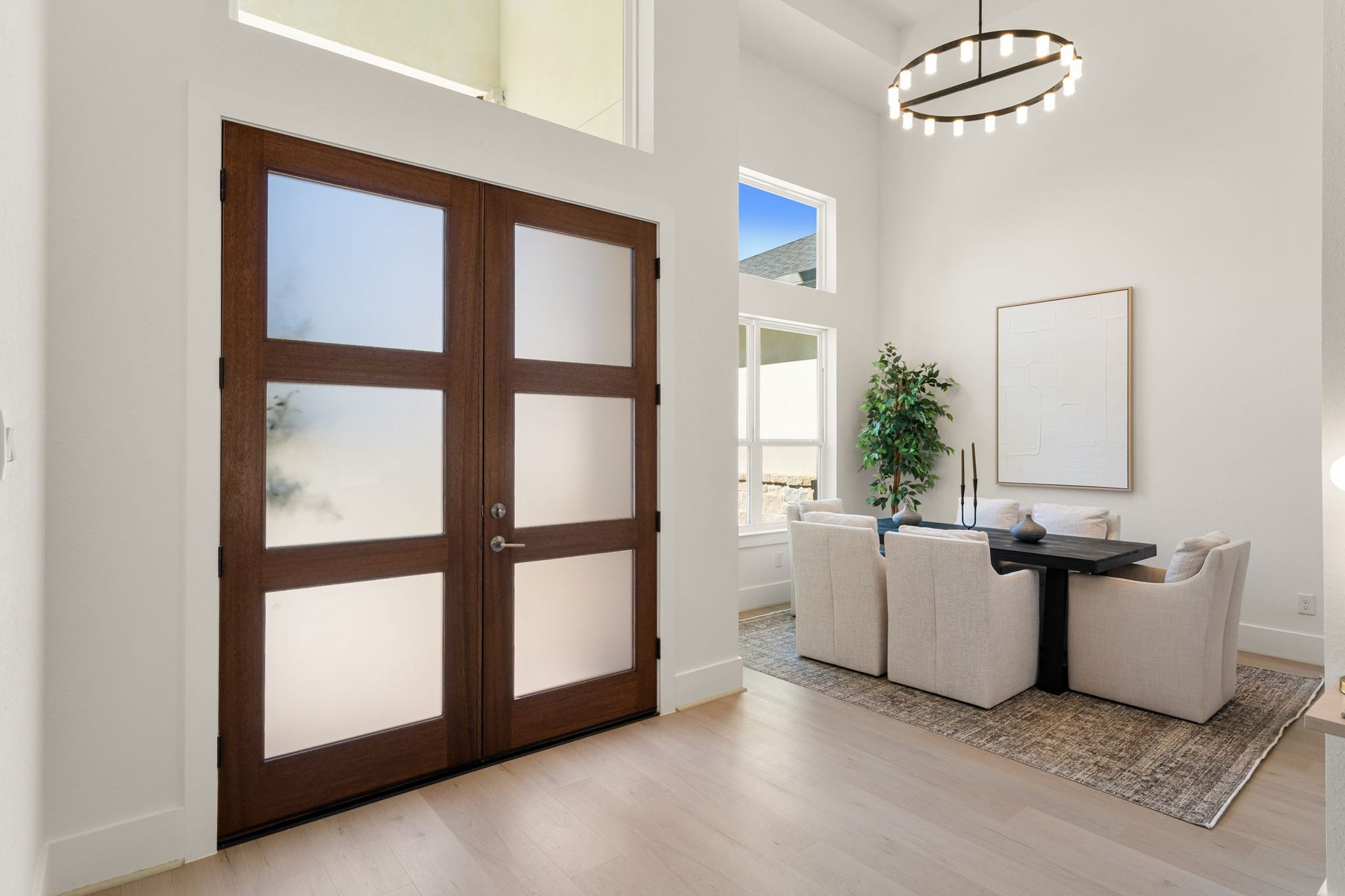 Impressive foyer featuring soaring ceilings, statement lighting, and elegant double entry doors.