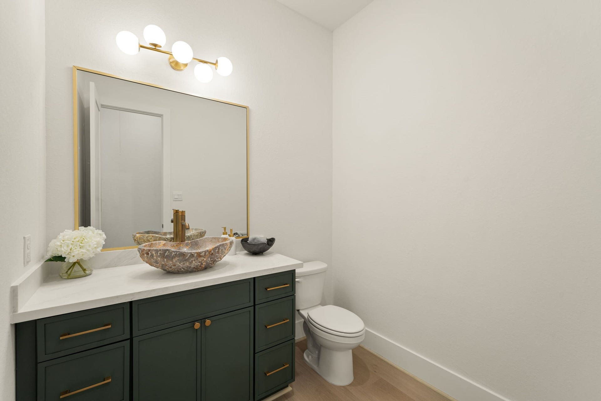 Stylish powder bathroom showcasing a beautiful vanity, modern fixtures, and elegant finishes.