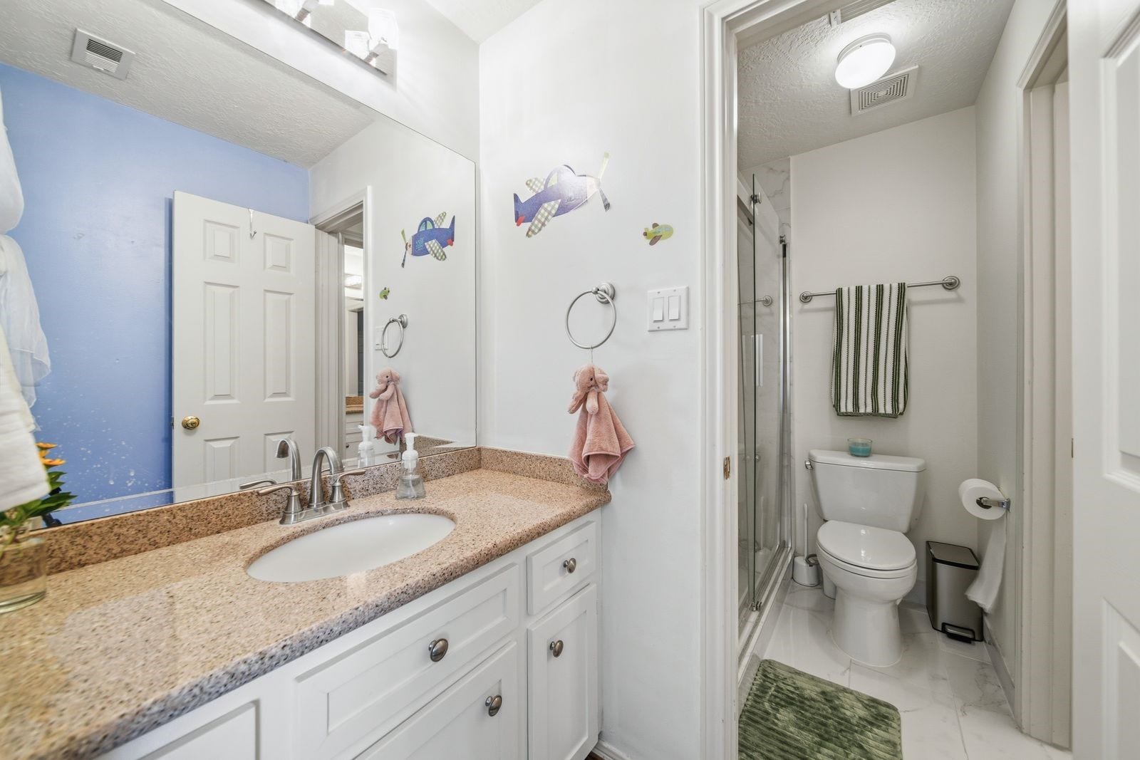 1606 Clearwater Creek Drive, Sugar Land, TX 77478 The Hollywood bath serves both bedrooms. Shower is updated with light tile and frameless glass enclosure.
