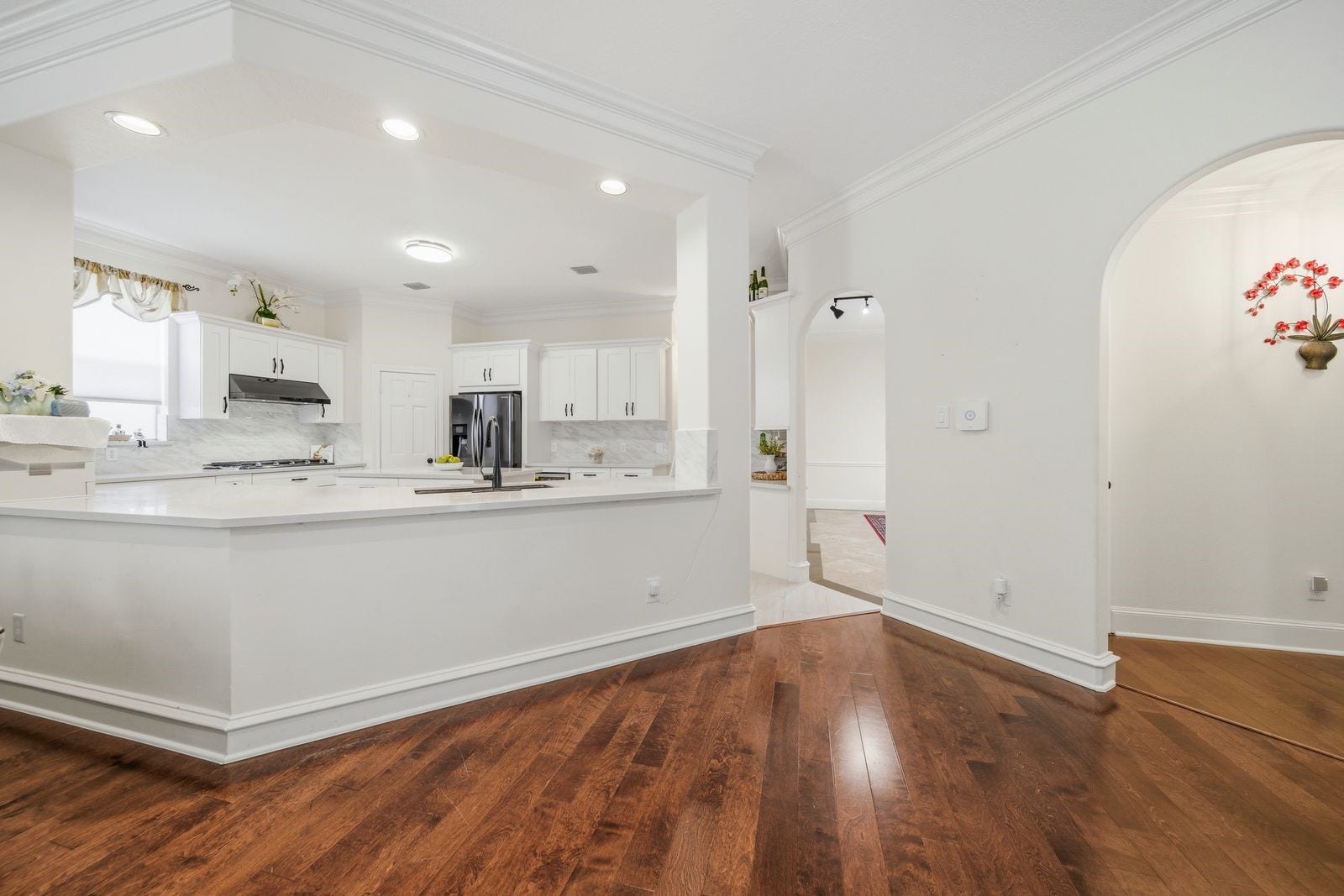 1606 Clearwater Creek Drive, Sugar Land, TX 77478 The bright white kitchen is accentuated by the dark, rich flooring.