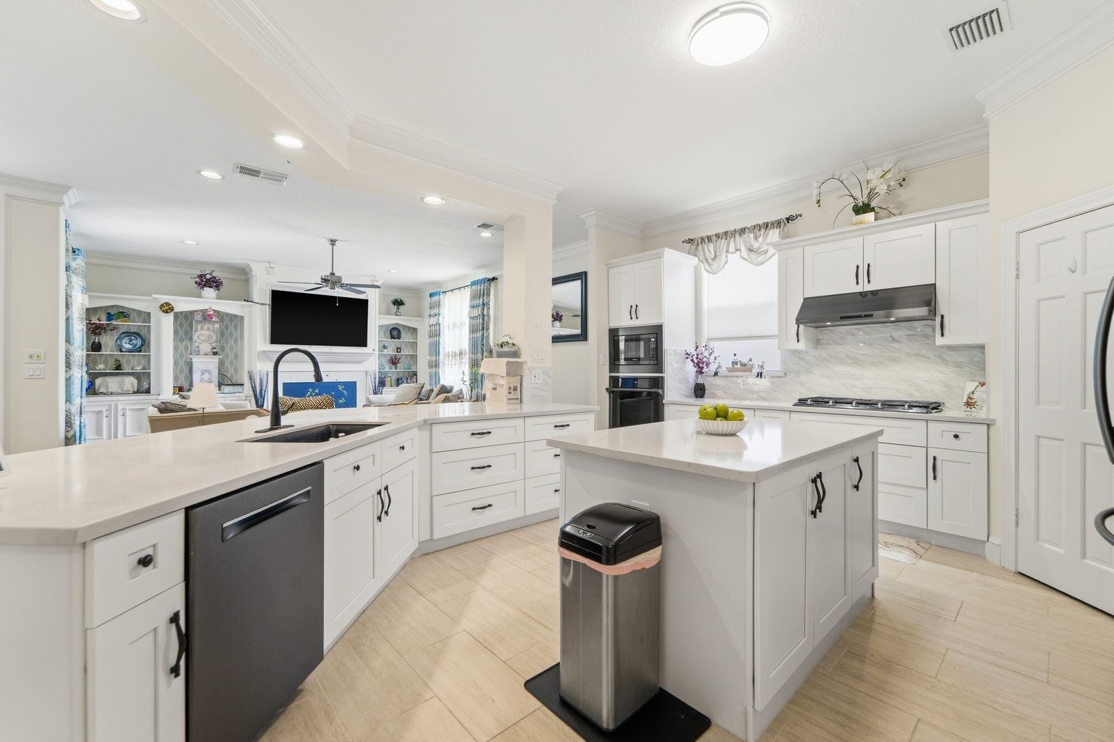 1606 Clearwater Creek Drive, Sugar Land, TX 77478 Open to the family room for easy entertaining. Lovely black stainless appliances and oversized black farm sink add to the elegant style of the kitchen.