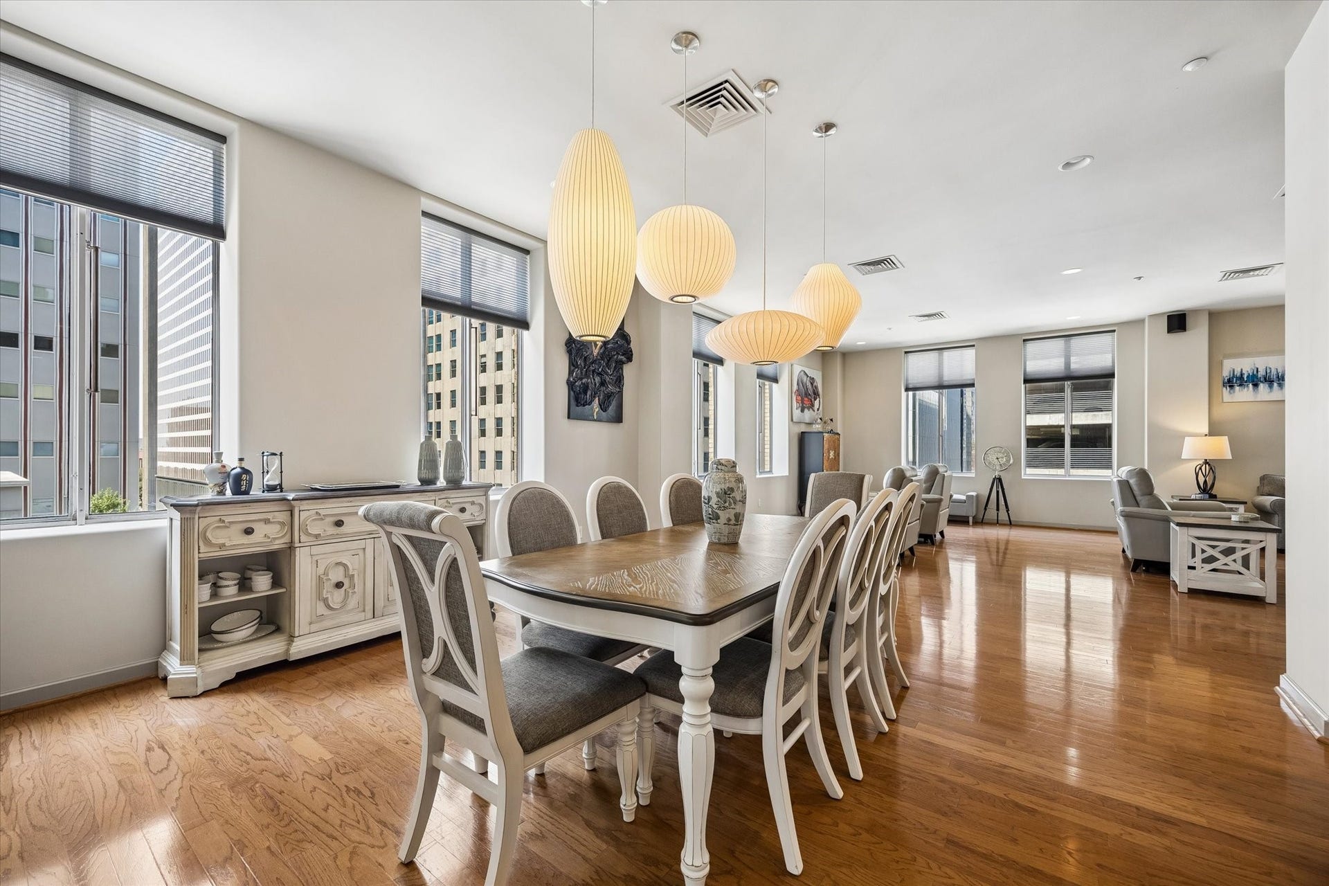 914 Main Street, #801, Houston, TX 77002 Spacious dining area with elegant lighting and large windows offering city views, seamlessly flowing into a cozy living space with modern decor.