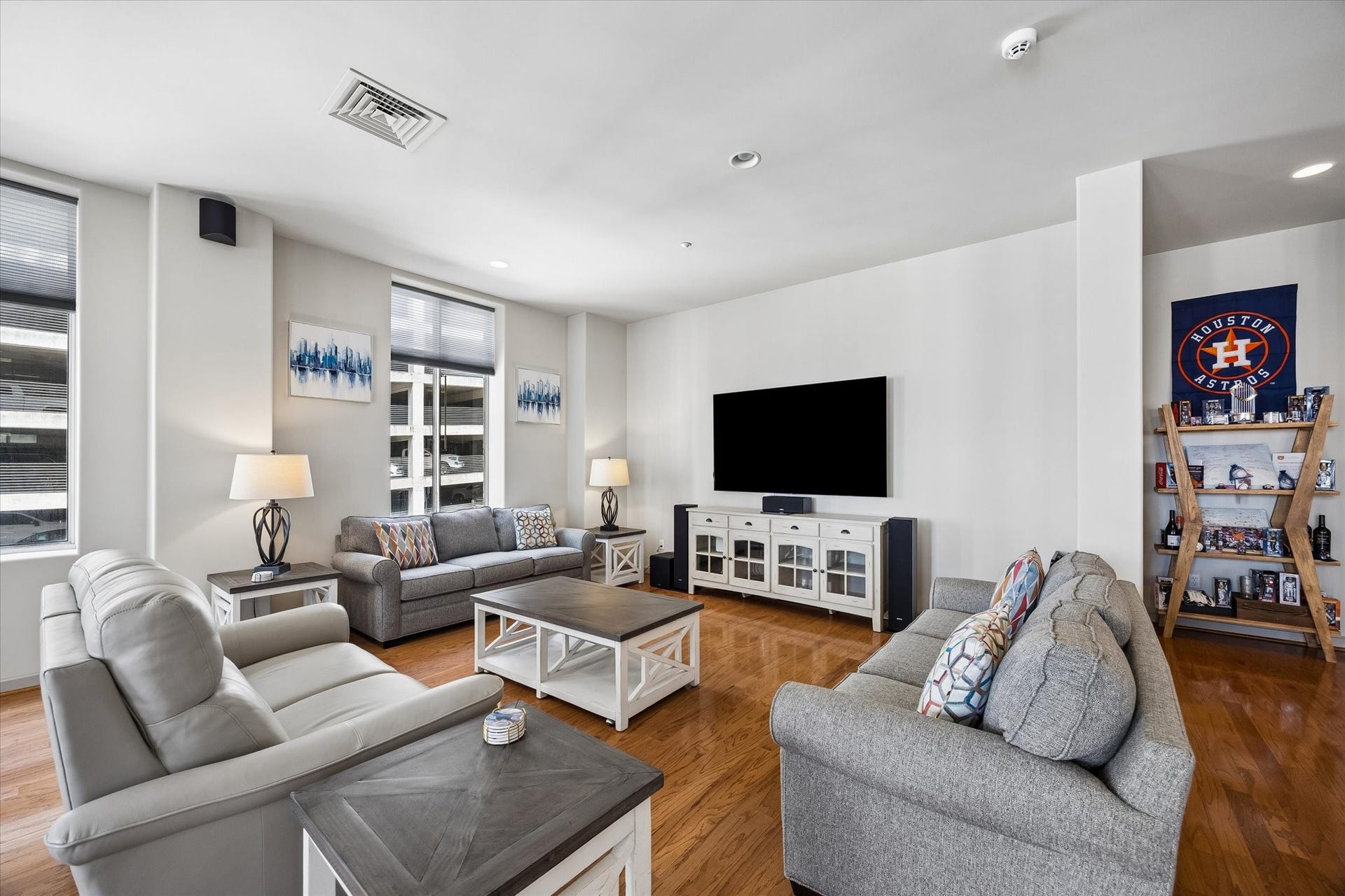 914 Main Street, #801, Houston, TX 77002 Spacious living room featuring sleek hardwood floors, comfortable seating, and a large wall-mounted TV, perfect for relaxation and entertainment.