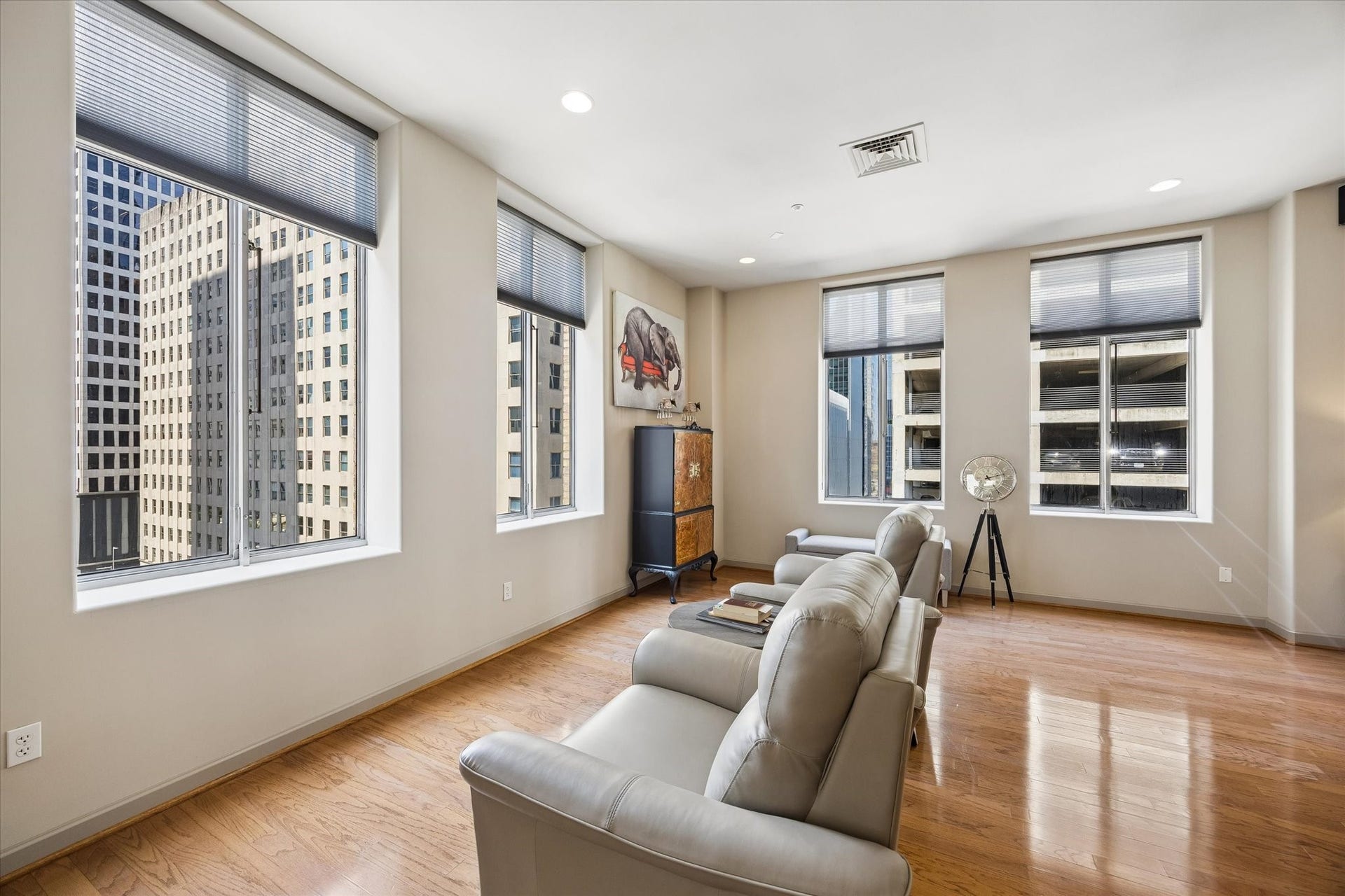 914 Main Street, #801, Houston, TX 77002 Spacious living area with abundant natural light from large windows offering stunning city views, complemented by stylish hardwood floors and modern furnishings.