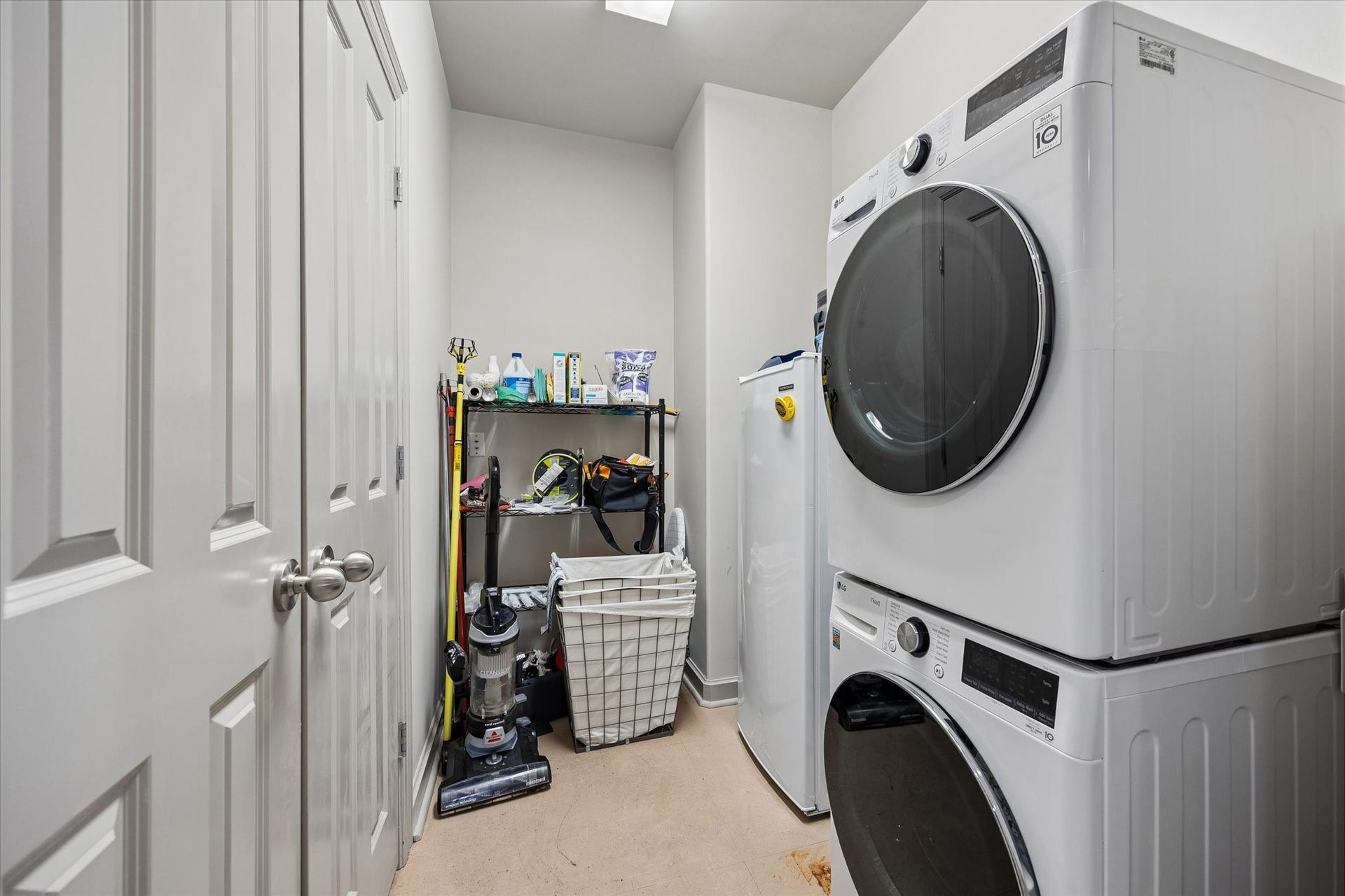 914 Main Street, #801, Houston, TX 77002 Efficient laundry room with stackable washer and dryer, ample shelving for storage, and additional space for cleaning supplies.