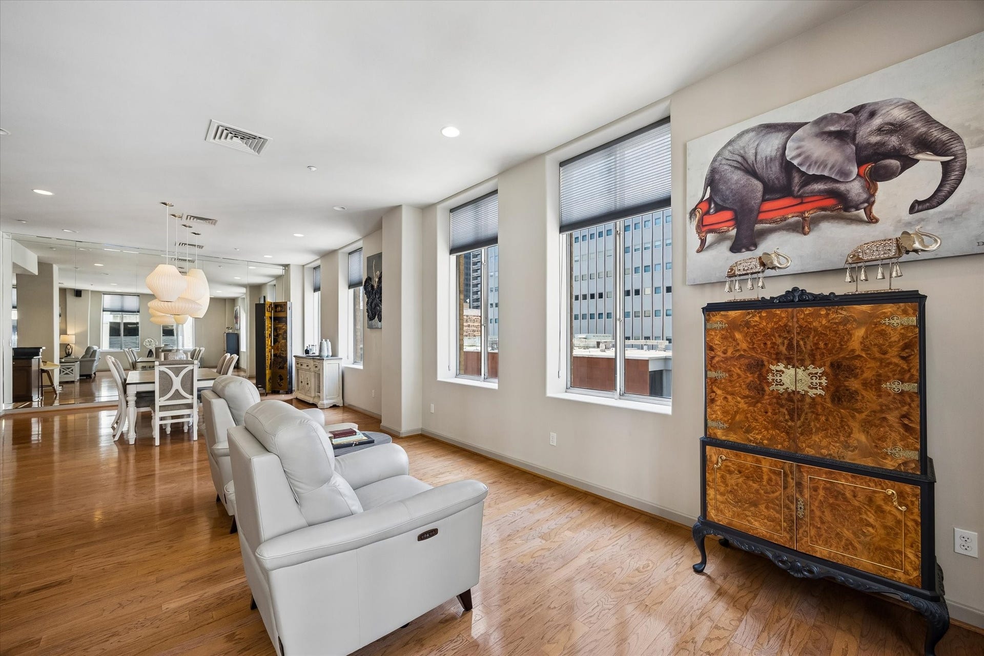 914 Main Street, #801, Houston, TX 77002 Spacious, modern living area with sleek hardwood floors, abundant natural light from large windows, and elegant white seating.