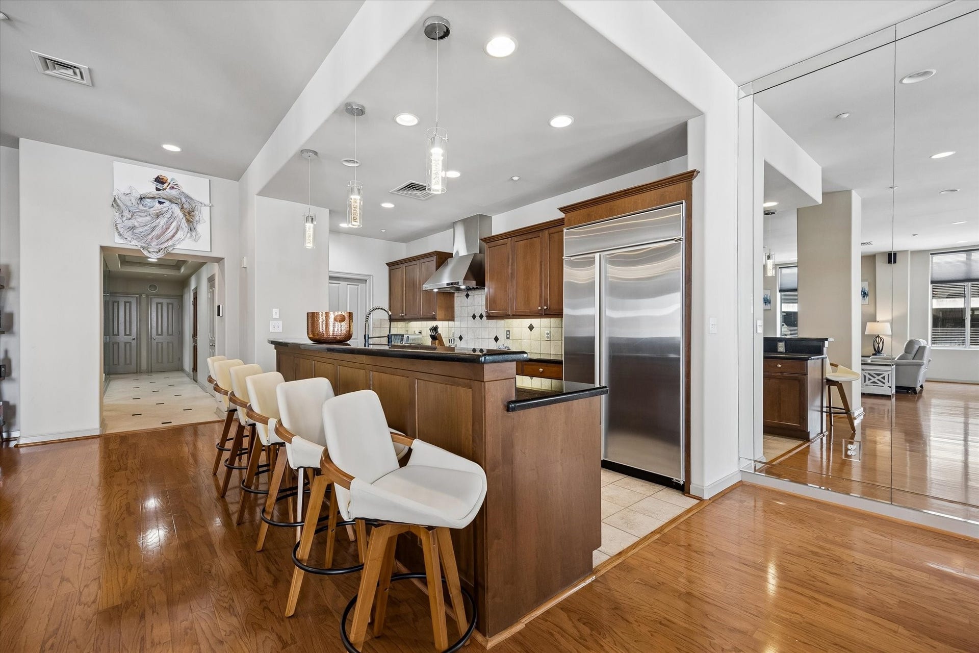 914 Main Street, #801, Houston, TX 77002 Spacious kitchen with sleek stainless steel appliances, elegant dark countertops, and a large breakfast bar with stylish seating, seamlessly flowing into an inviting open-concept living area.