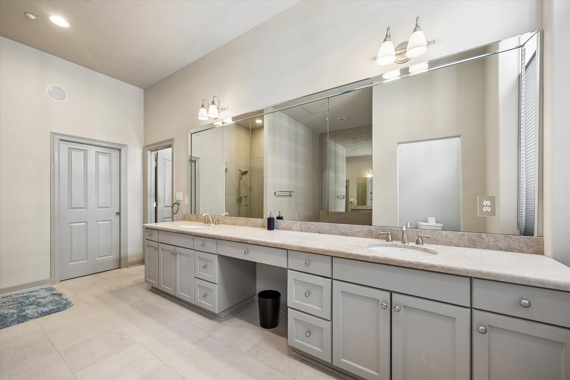 914 Main Street, #801, Houston, TX 77002 Spacious bathroom featuring a long double vanity with ample storage, a large mirror, and elegant lighting, complemented by a sleek walk-in shower.