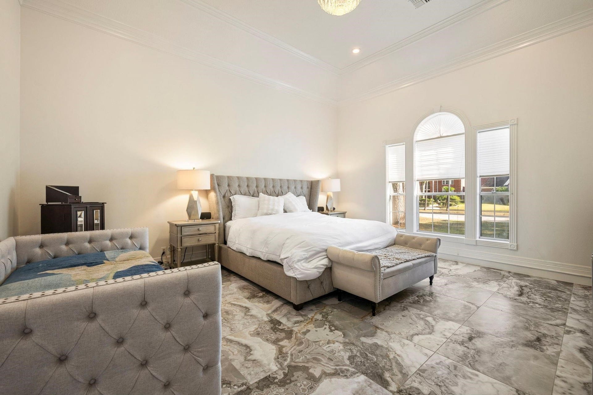 2922 Cedar Woods Place, Houston, TX 77068 Extremely spacious and filled with natural light, the Primary Bedroom showcases soaring ceilings, crown molding, a statement chandelier, and a large window that enhances its elegant scale.