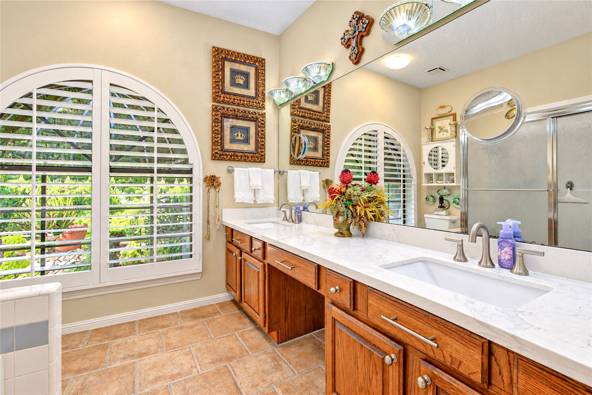 6839 Hertford Park Drive, Houston, TX 77084 The updated primary bath features a long vanity with two sinks and a beautiful arched window.