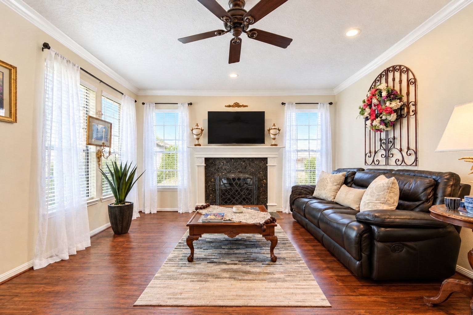 6839 Hertford Park Drive, Houston, TX 77084 A welcoming living room with a fireplace framed by windows and carpet-free flooring.